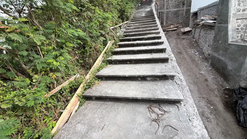 Struktur tangga luar pada tahap pekerjaan sipil di lokasi berkontur.